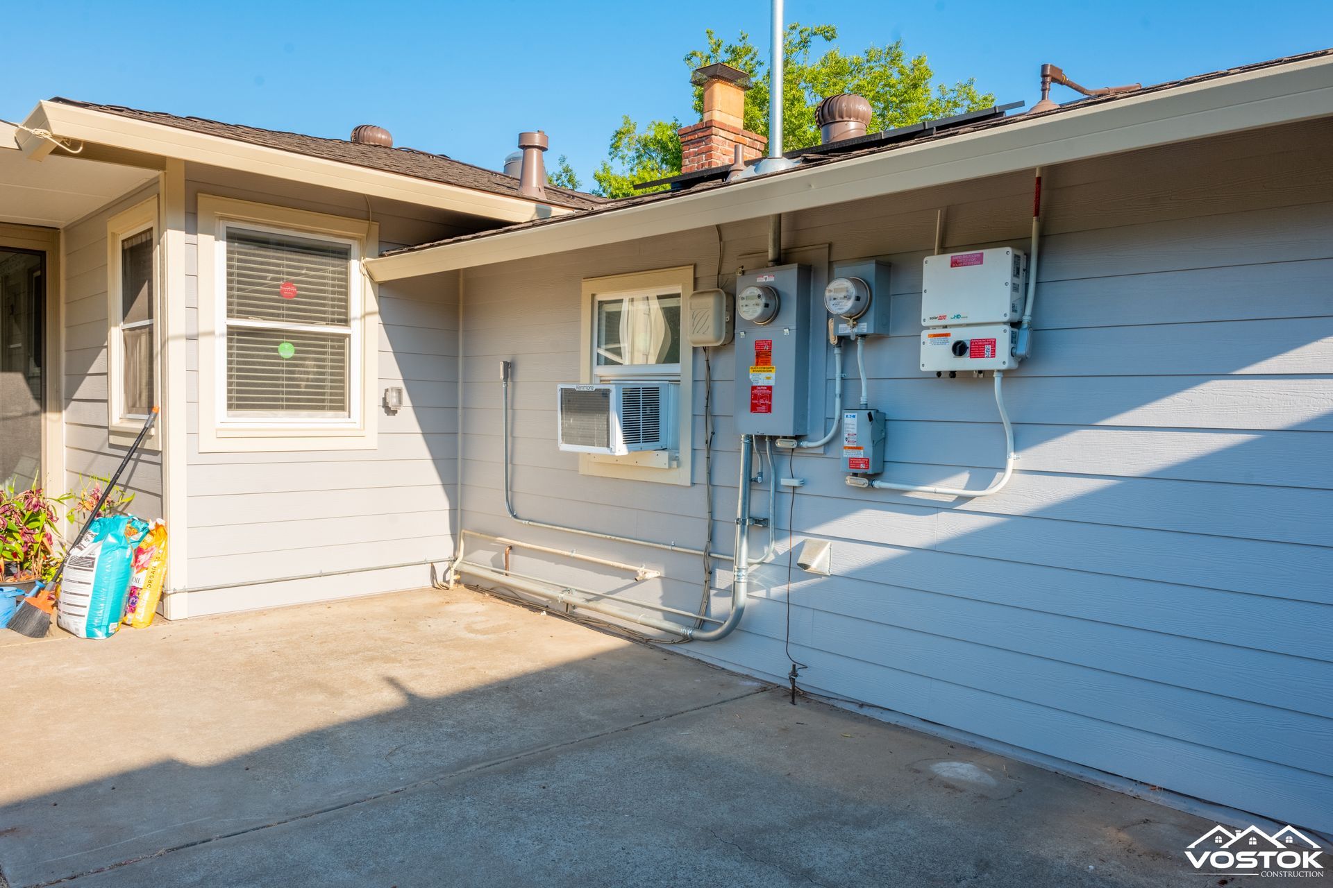 A house with a lot of electrical outlets on the side of it.