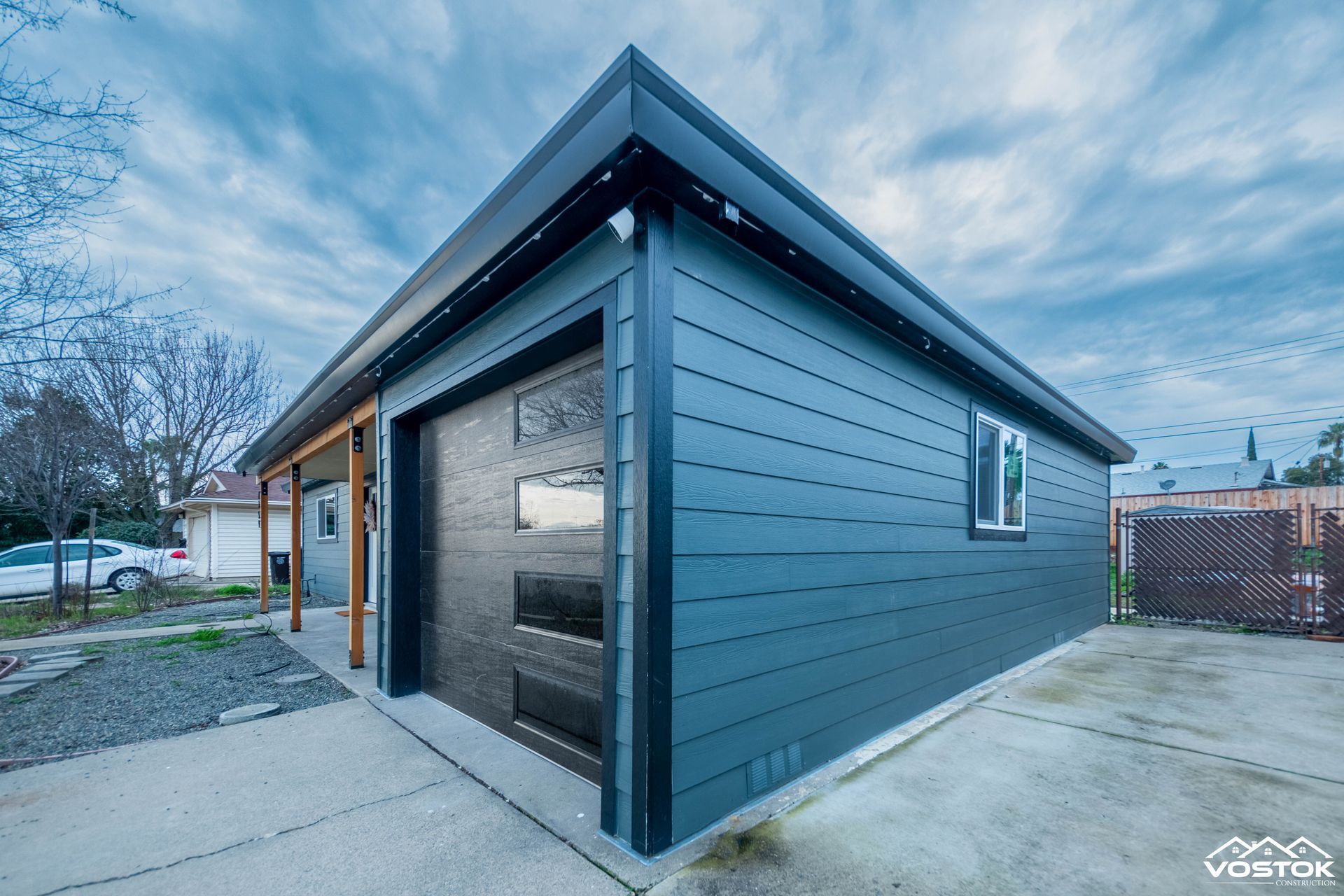 A small blue garage with a roof and a window