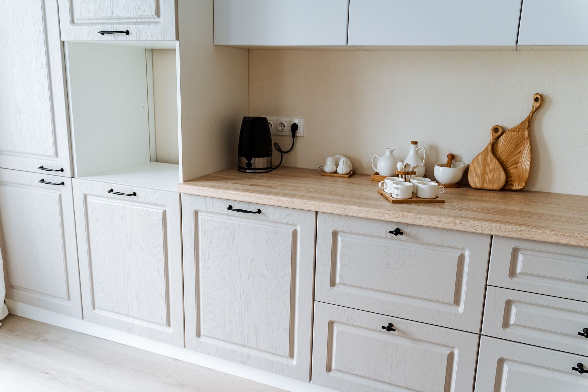 A kitchen area with white cabinets