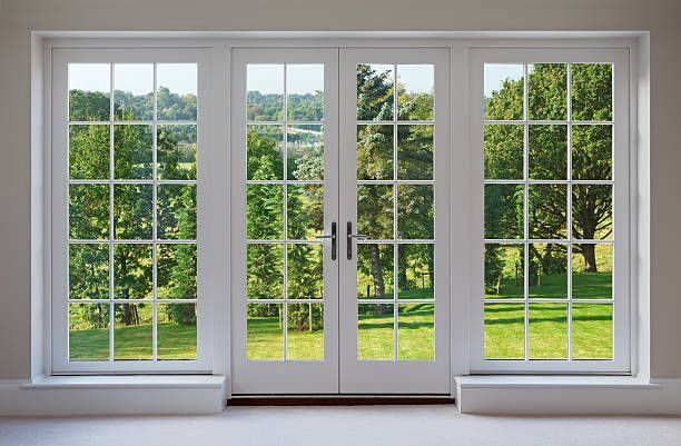 A room with a lot of windows and a view of a park.