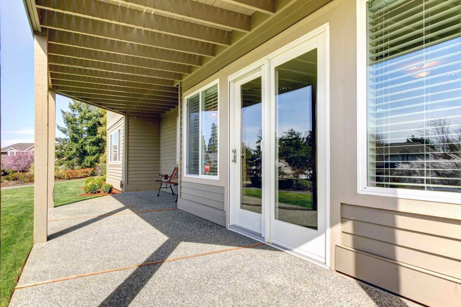 There is a patio with sliding glass doors and a pergola.