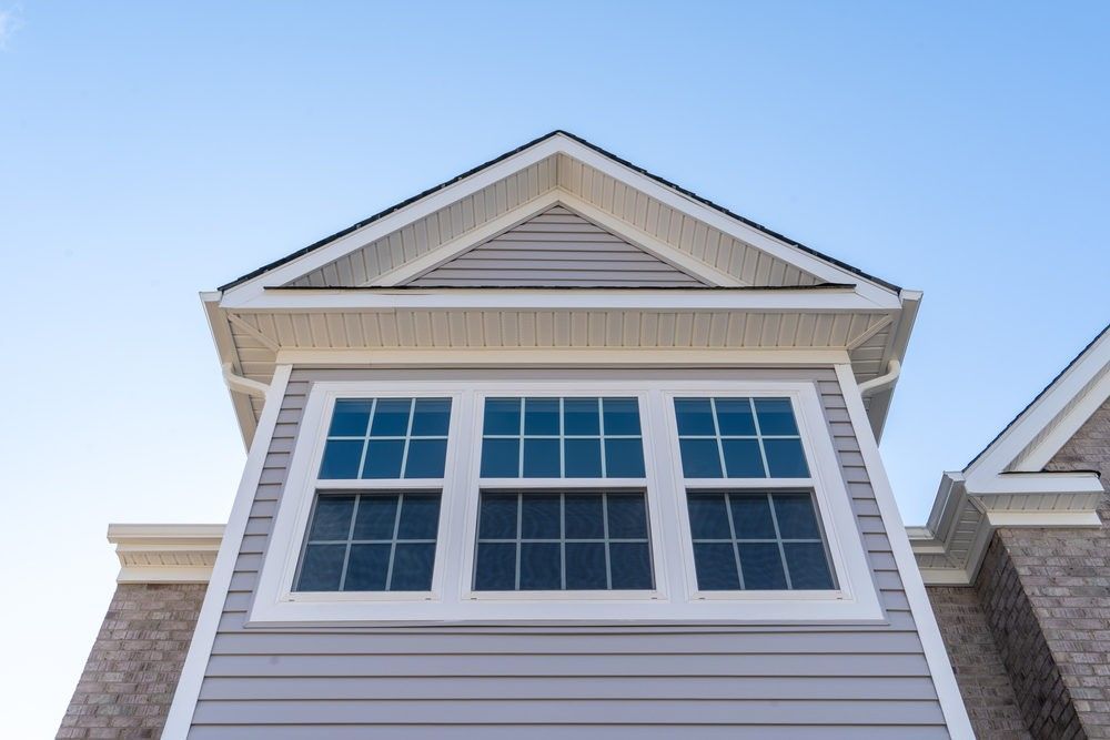 Looking up at the roof of a house with a blue sky in the background.