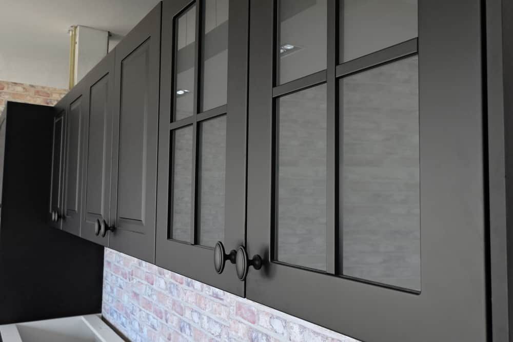 A Kitchen With Black Cabinets And Glass Doors — South East Kitchens In Burleigh Heads, QLD