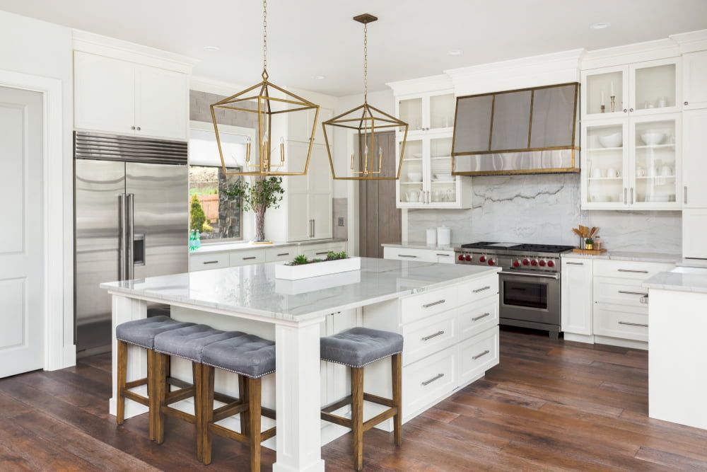 A Kitchen With White Cabinets, Steel Appliances, A Large Island And Stools — South East Kitchens In Burleigh Heads, QLD