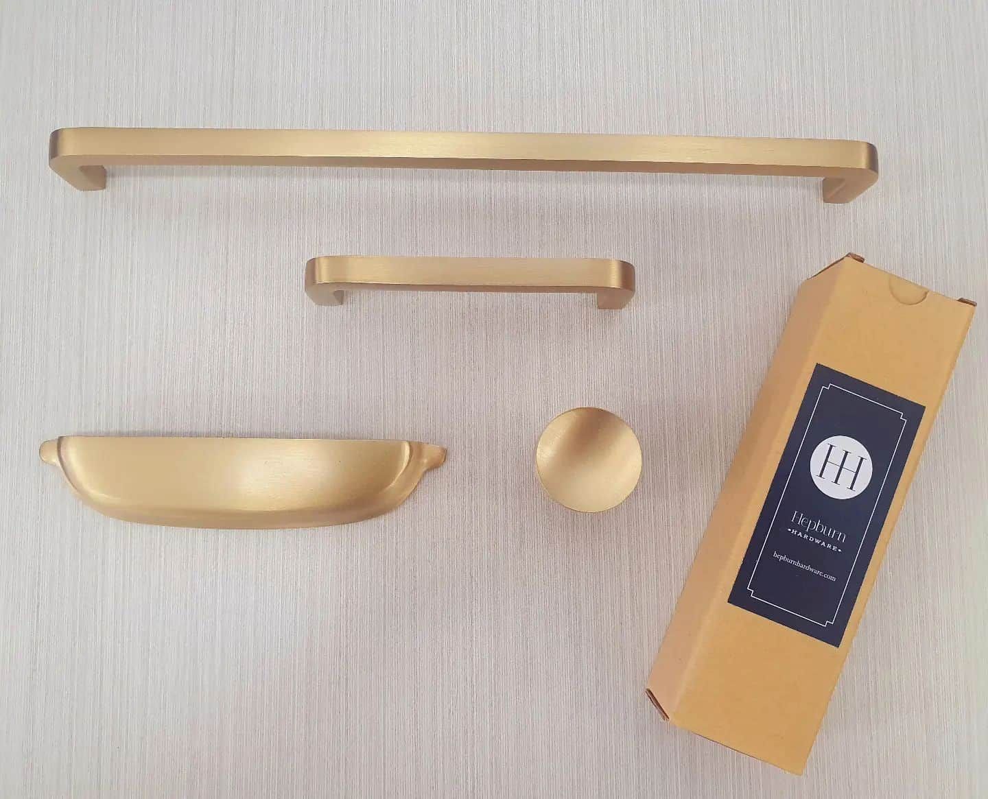 A Set Of Brass Cabinet Handles And Knobs Next To A Box — South East Kitchens In Brisbane, QLD