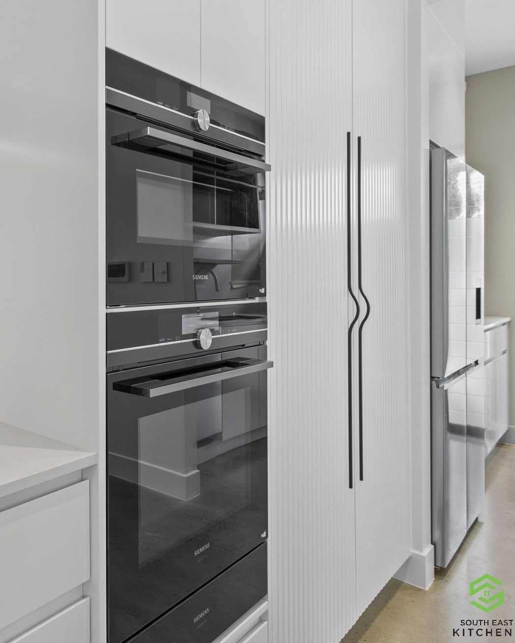 A Kitchen With A Black Oven And A White Refrigerator — South East Kitchens In Burleigh Heads, QLD