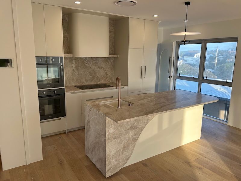 A Cream Stone Kitchen With A Sink, Stove oven and A Window — South East Kitchens In Burleigh Heads, QLD