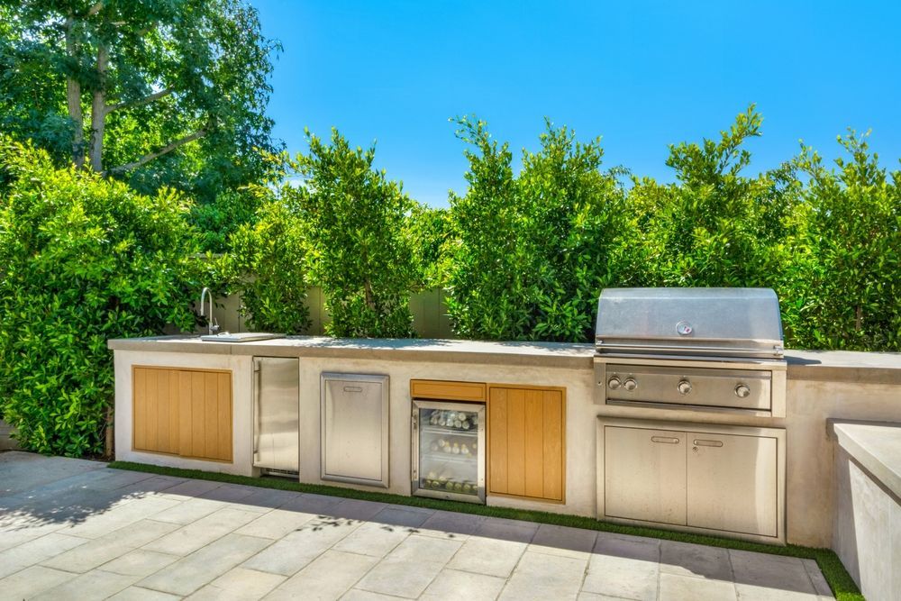 Backyard pool area with outdoor kitchen pavilion