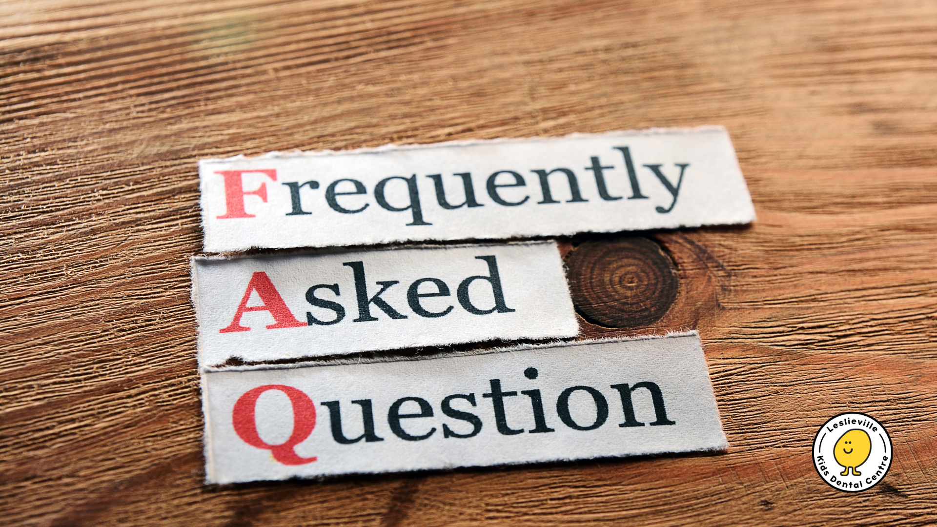 FAQ letters on paper strips, stacked on wood.