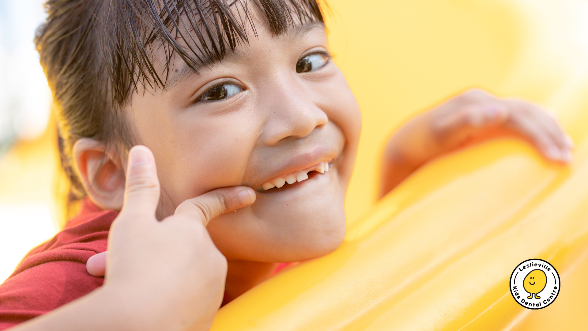 A little girl is making a funny face and giving a thumbs up.
