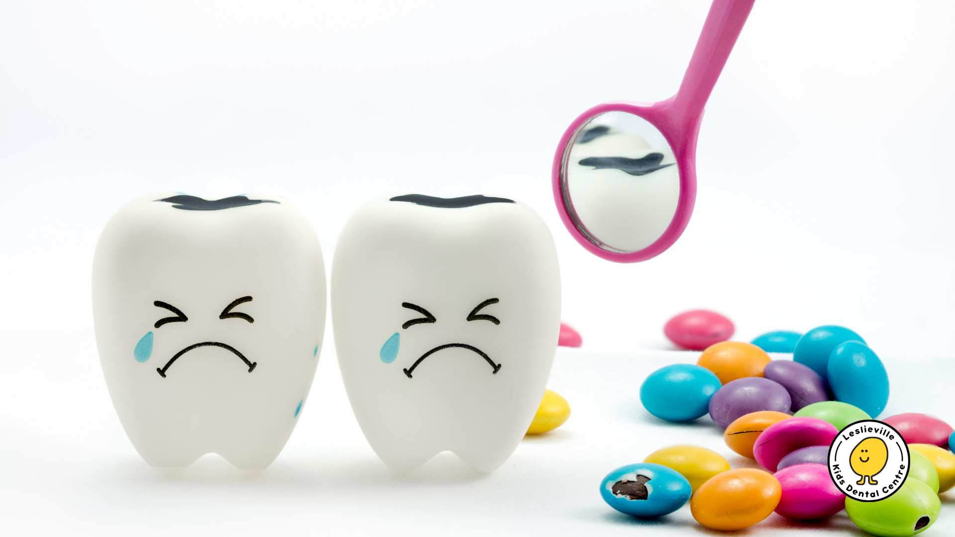 Two teeth with sad faces next to candy and a mirror