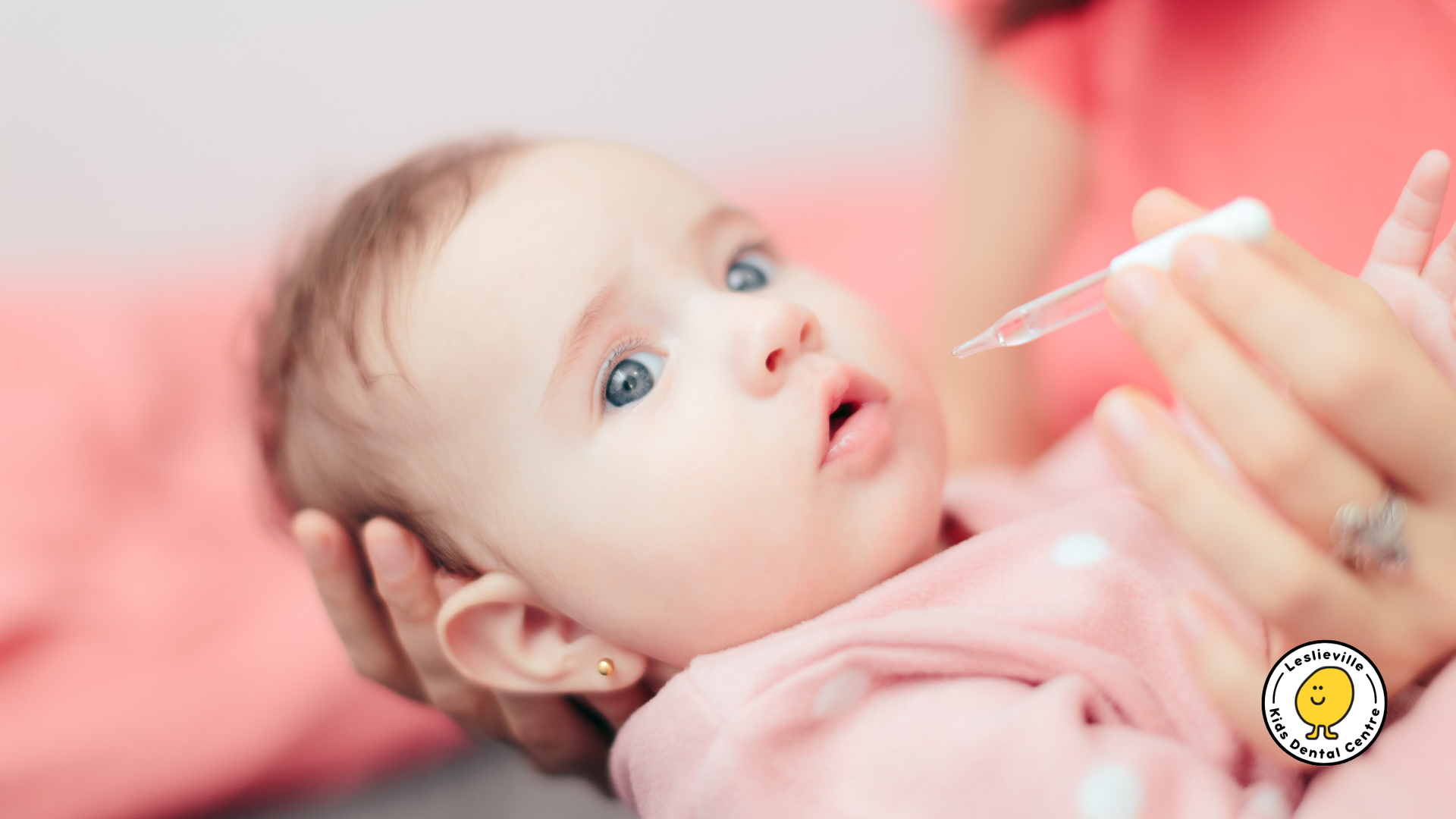 A woman is feeding a baby with a syringe.
