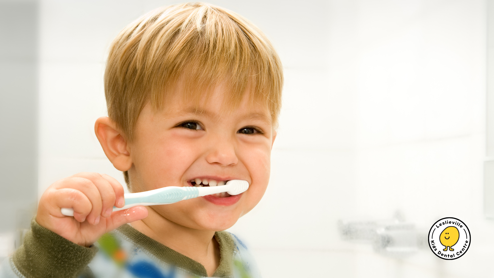 A young boy is brushing his teeth with a blue toothbrush.
