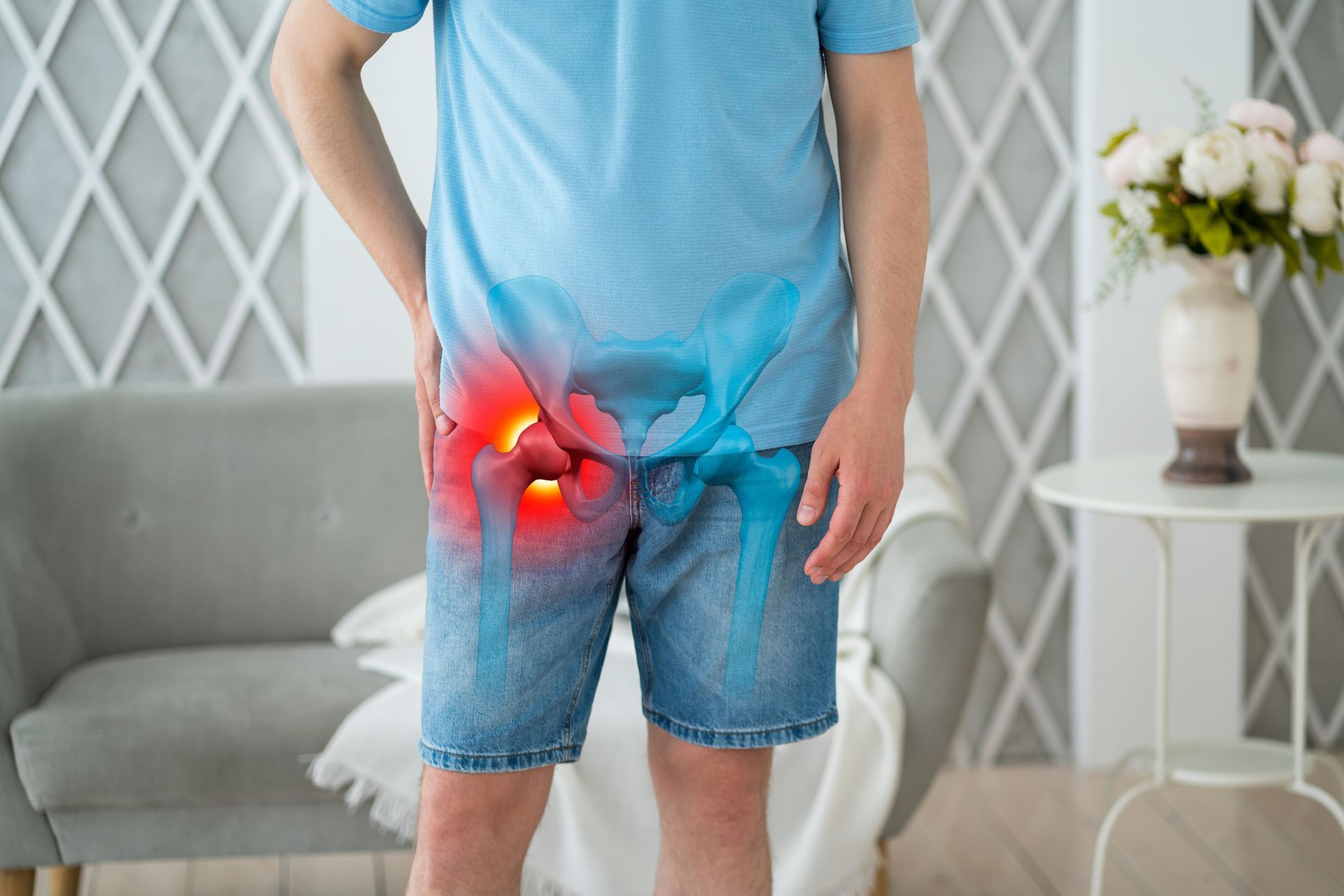 A man is standing in a living room with his knee in pain.