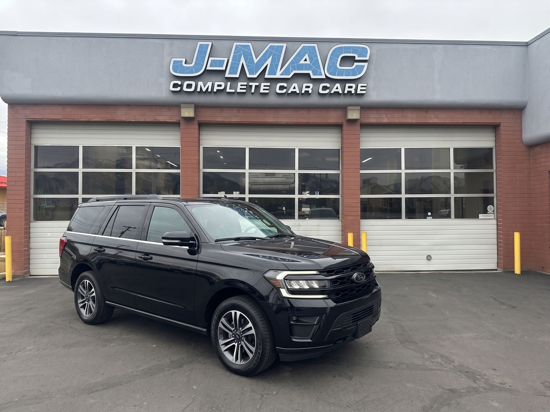Black SUV parked in front of J-MAC Complete Car Care garage