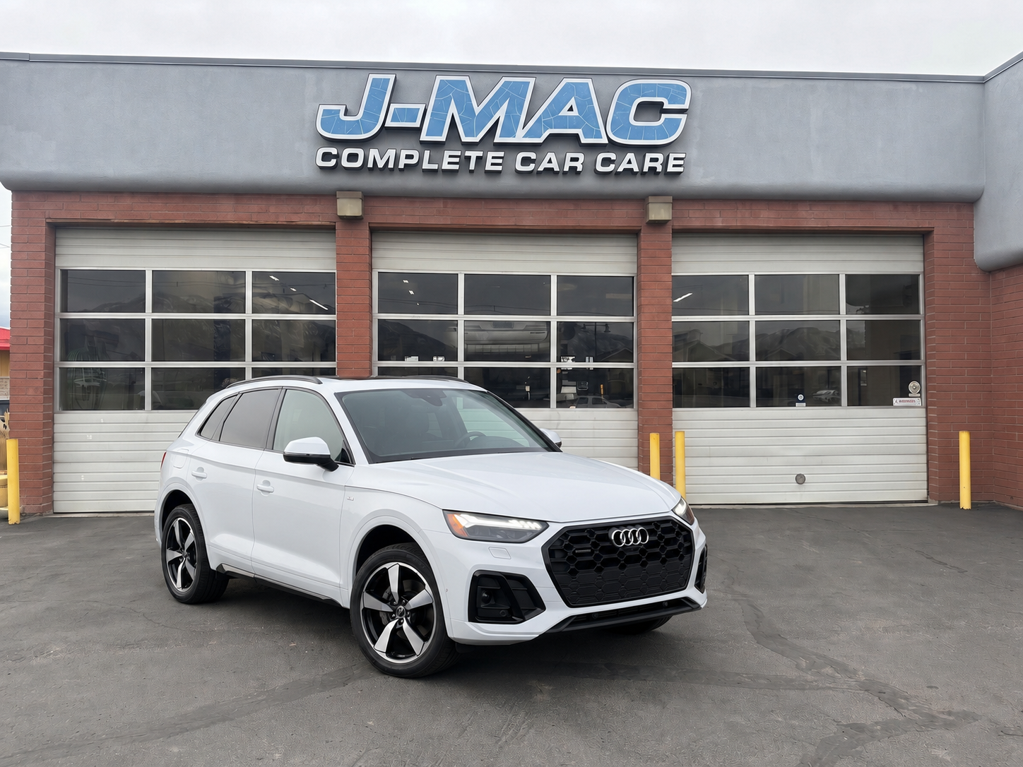 White SUV parked in front of J-MAC Complete Car Care garage
