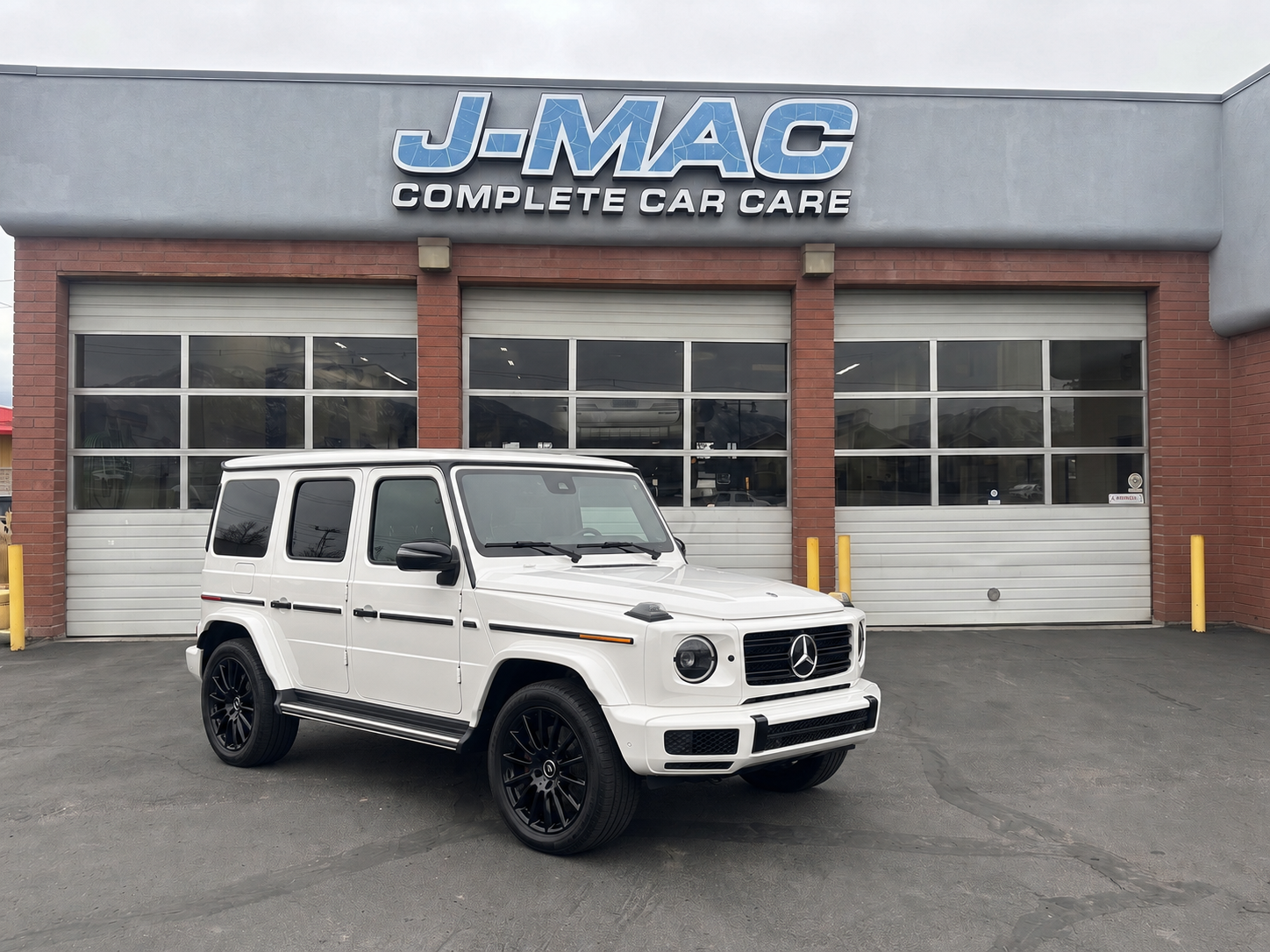 White SUV parked outside J-MAC Complete Car Care garage