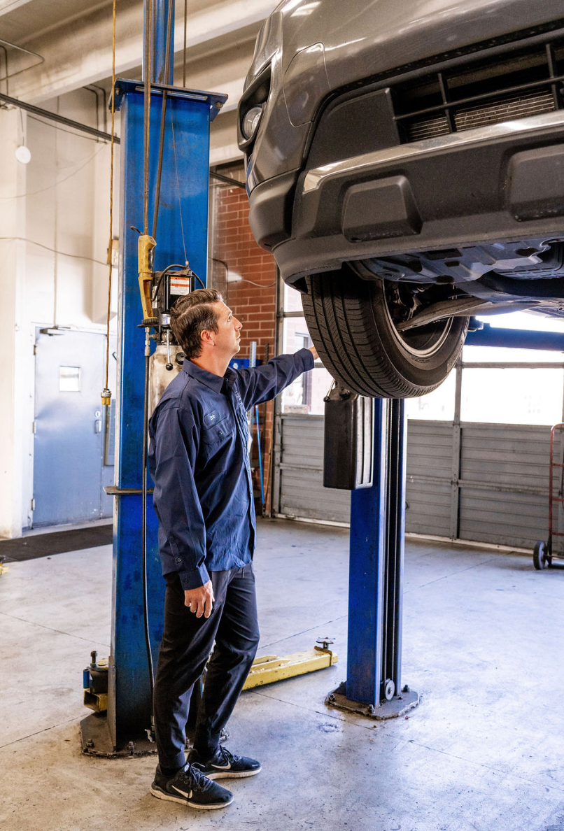 Mechanic inspecting a car on a lift in an auto repair shop