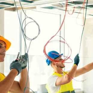 Horizon Electric USA - Two men are working on electrical wires hanging from the ceiling.