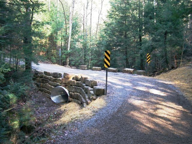 A road with a yellow and black sign on it