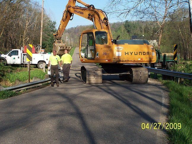 A hyundai excavator is on the side of the road
