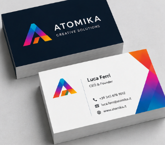 Due biglietti da visita ATOMIKA, uno bianco e uno blu scuro, con logo triangolare colorato e recapiti.