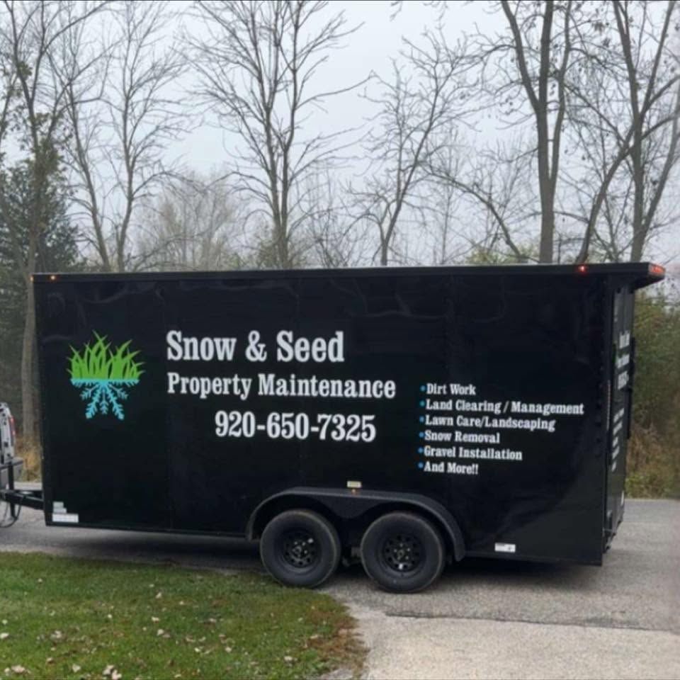 Black trailer for Snow & Seed Property Maintenance with logo, phone number, and service list in a driveway