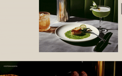 Elegant plated dinner with green sauce and cocktails on a table in a dimly lit restaurant