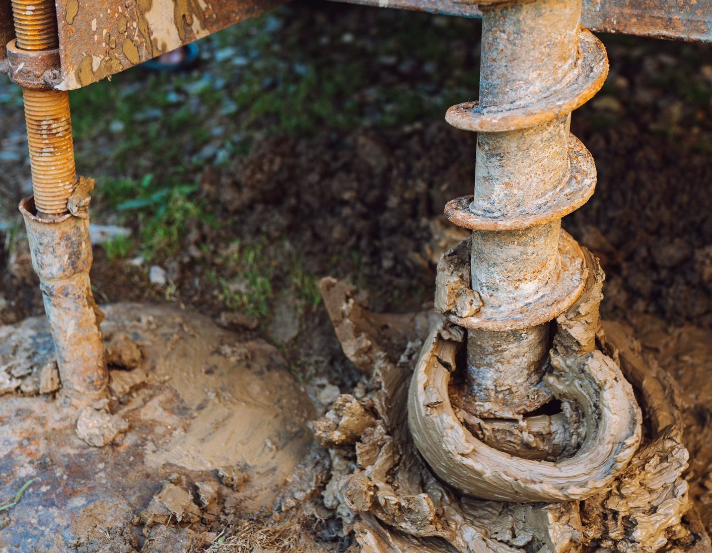 A close up of a drill bit in the ground. A close up of a drill bit in the ground.