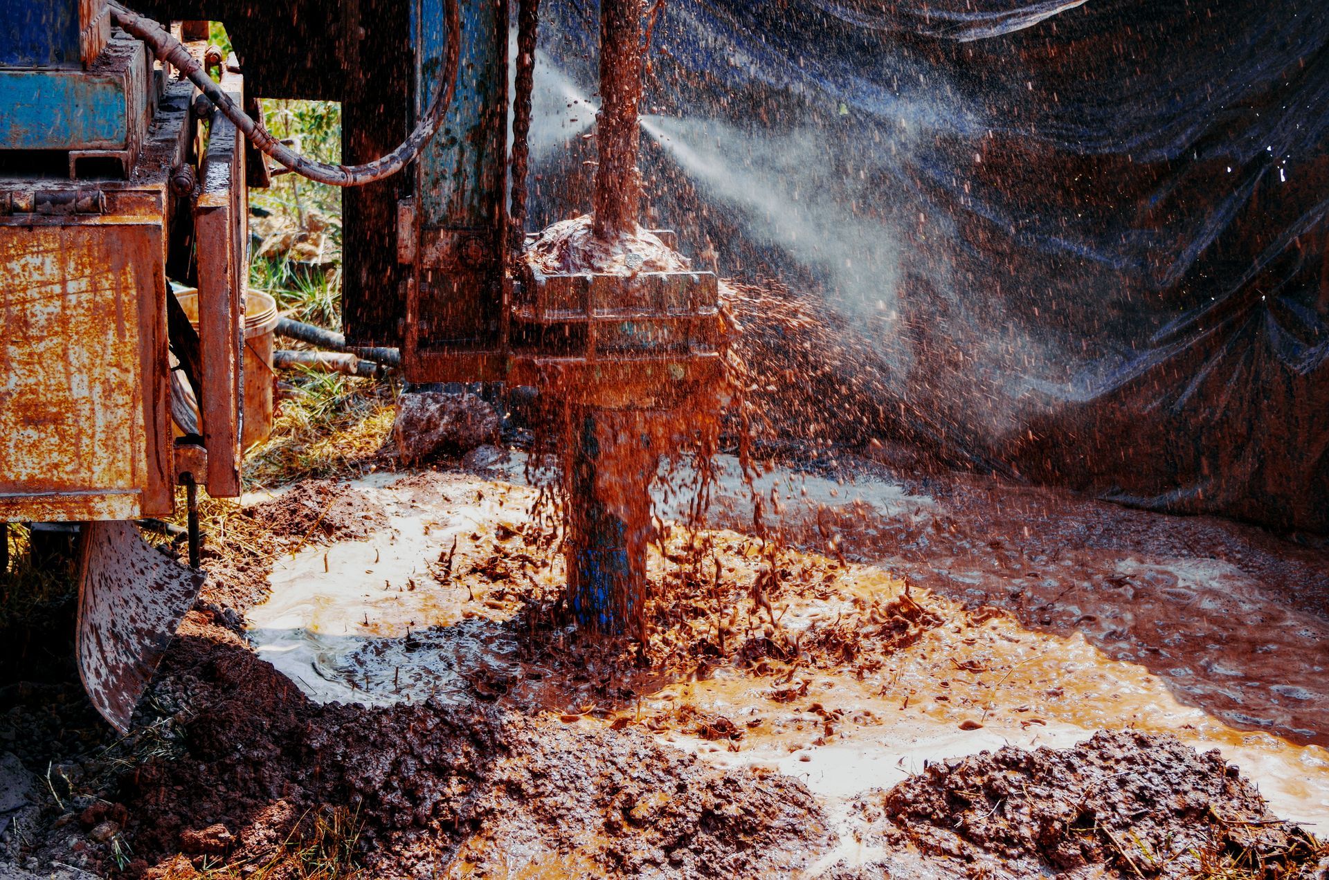 A machine is working in a muddy area with water spraying out of it A machine is working in a muddy area with water spraying out of it
