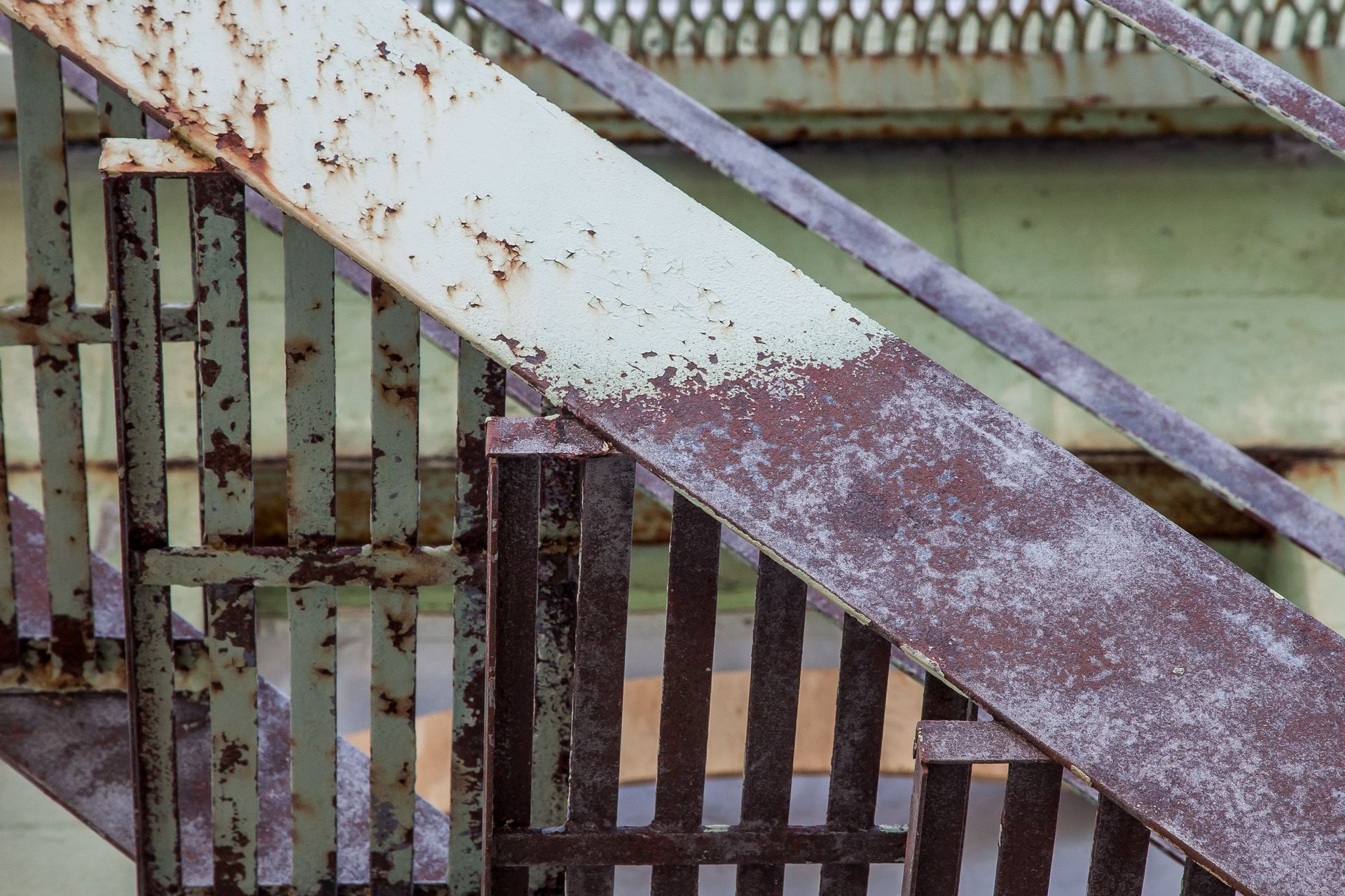 Un gros plan d'un escalier en métal rouillé avec une rampe blanche.