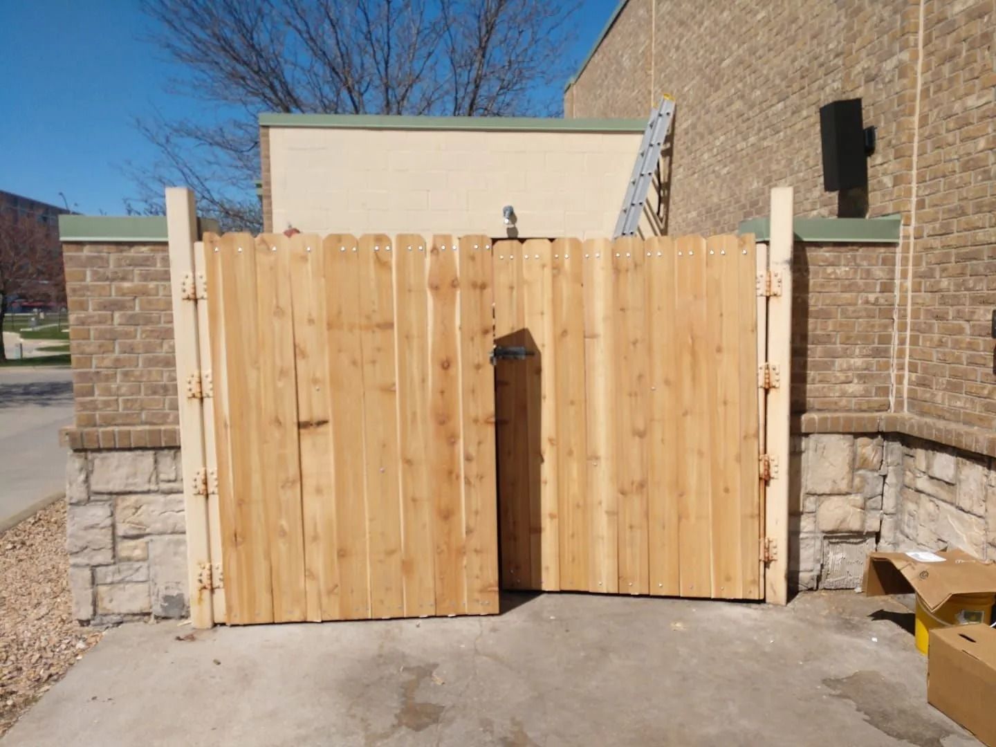 Wooden privacy gate between brick pillars in an outdoor alleyway