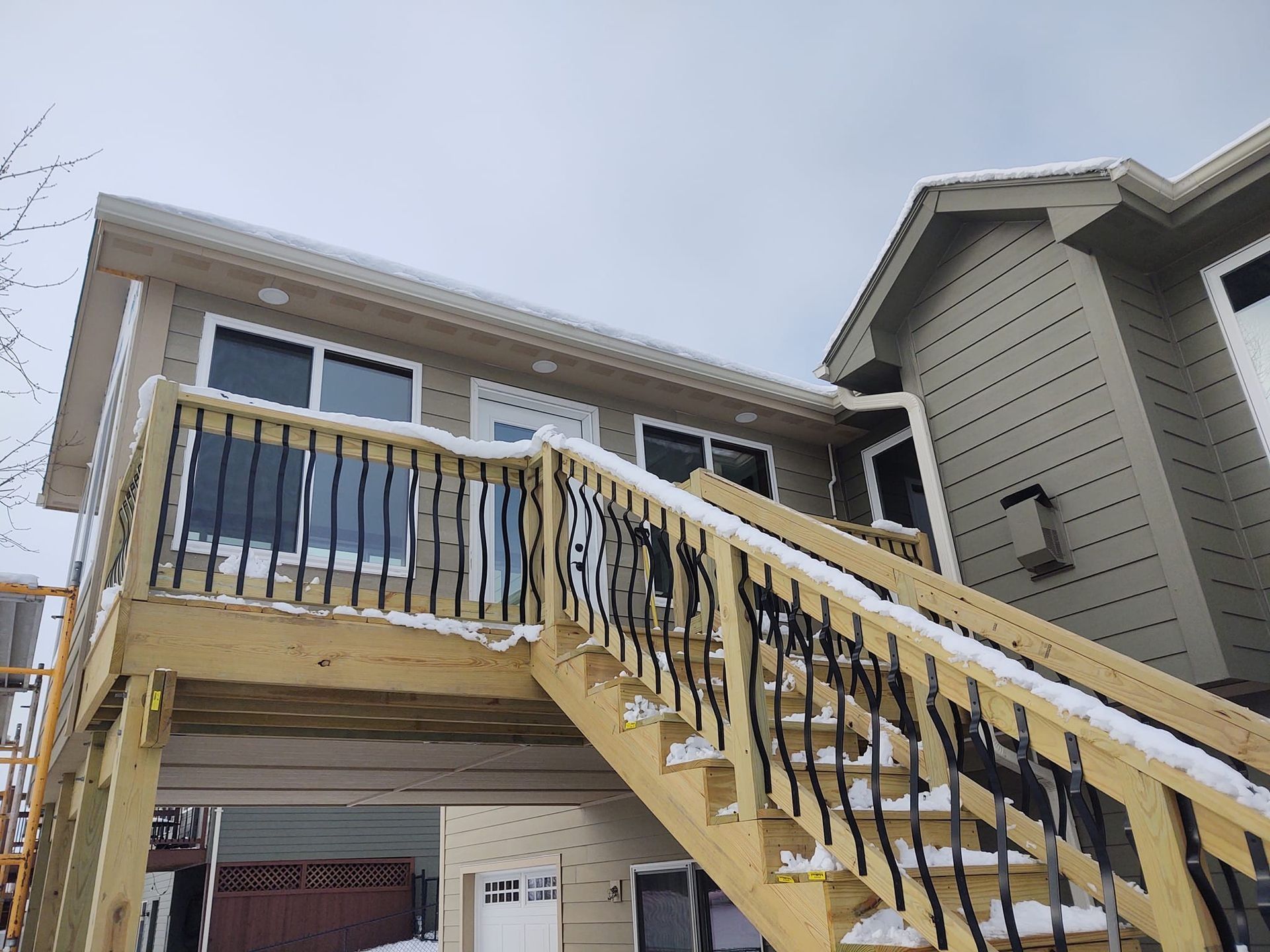 Wooden outdoor staircase leading to an elevated deck on a house