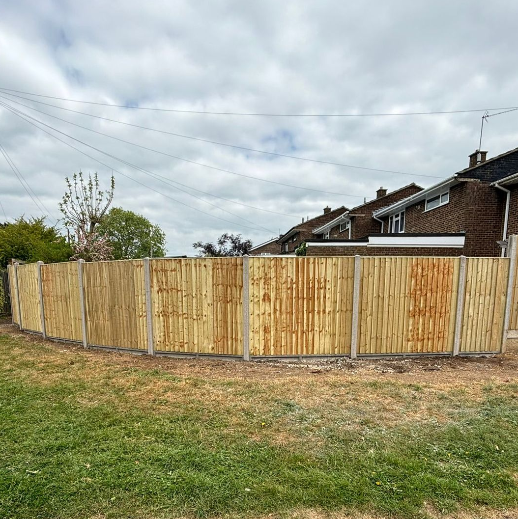 New fencing with houses in background and cloudy sky