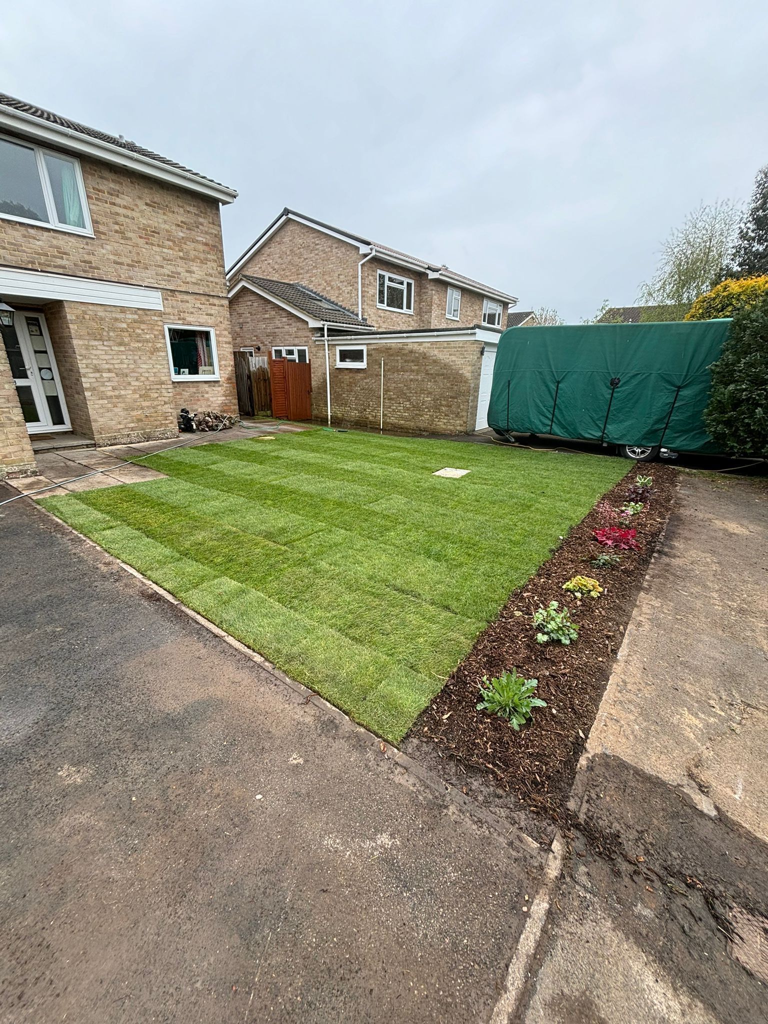Rear garden with house to the left and new turf laid