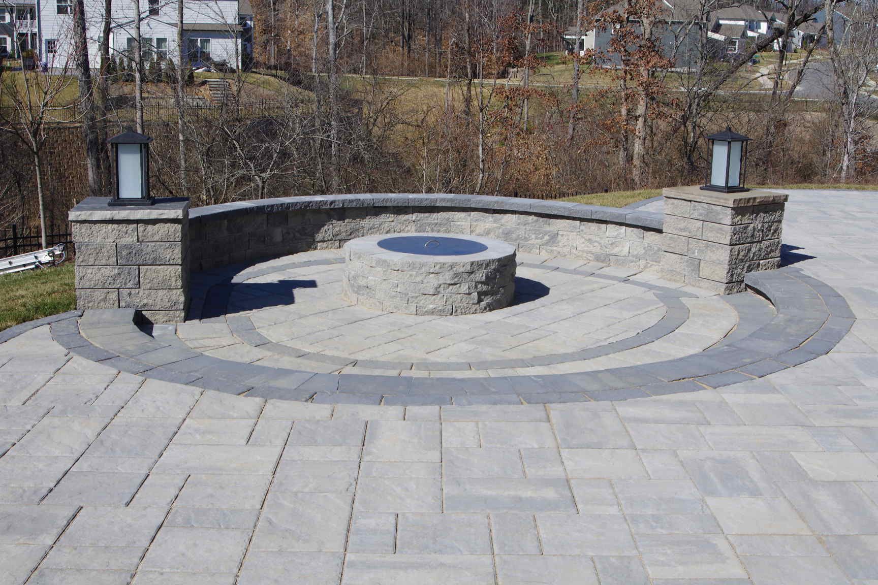 Stone memorial plaza with a circular bench and central low fountain basin outdoors