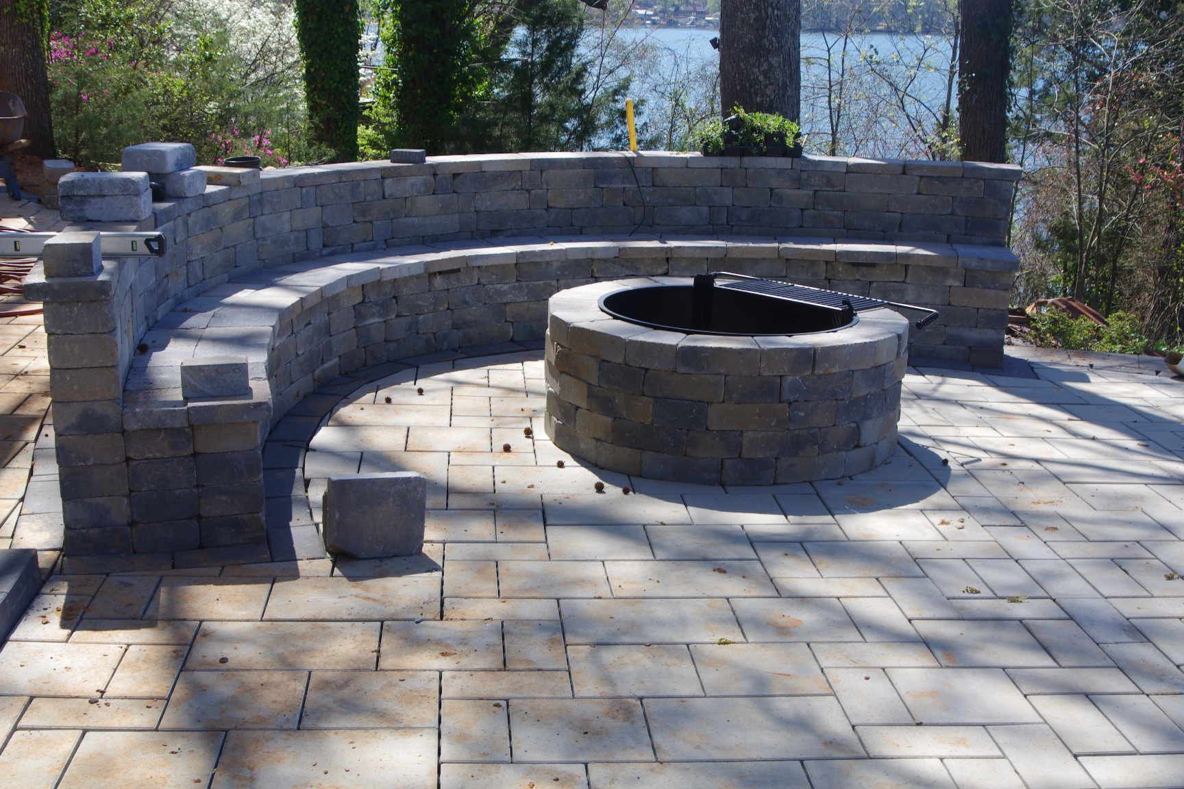 Stone patio with a curved bench and circular fire pit in an outdoor courtyard