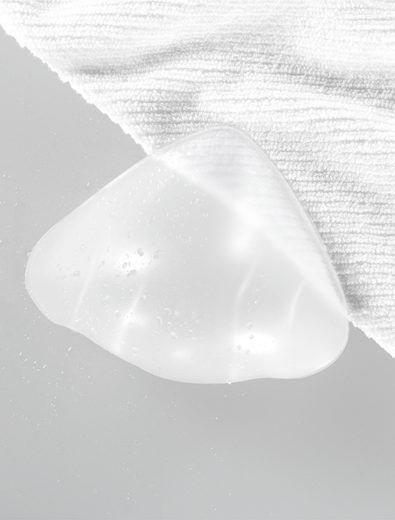 Clear, tear-shaped gel pack, resting on a white, textured cloth.