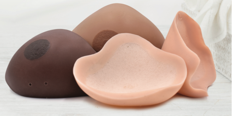 Collection of various breast prostheses in different shapes and skin tones.