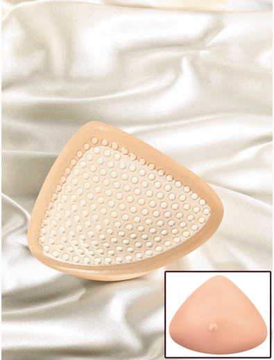 A beige, triangular breast prosthesis with a textured surface, shown on a satin background.