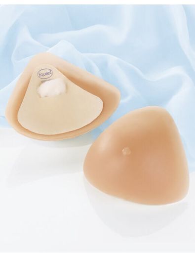 Two beige breast prostheses, one inside-out, on a light blue fabric background.