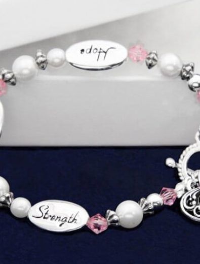 Bracelet with white pearls, pink crystals, and silver charms; one charm says 