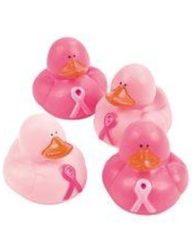 Four pink rubber ducks with pink ribbons on their chests.
