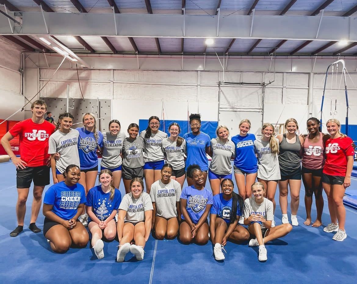 A group of young girls are posing for a picture in a gym.