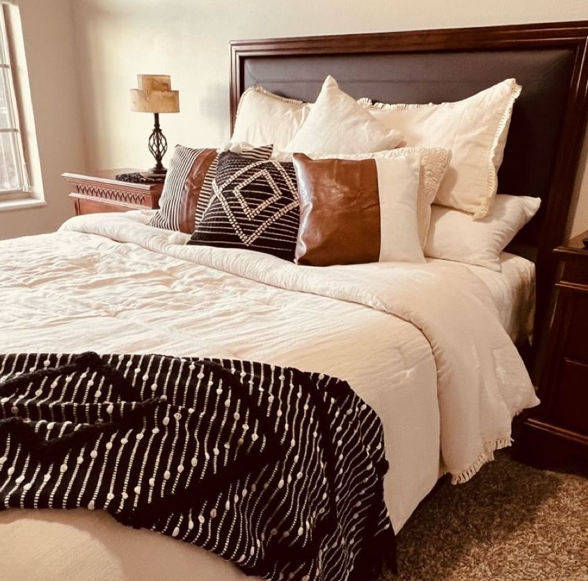 nicely made queen size bed with throw pillows