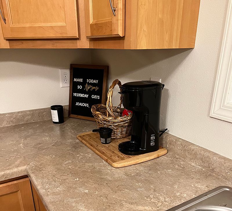 kitchen counter with coffee maker and cute sign