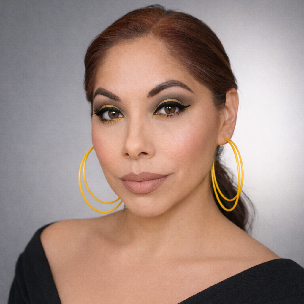 Woman with gold eyeshadow and hoop earrings in business for herself, but a part of a community.