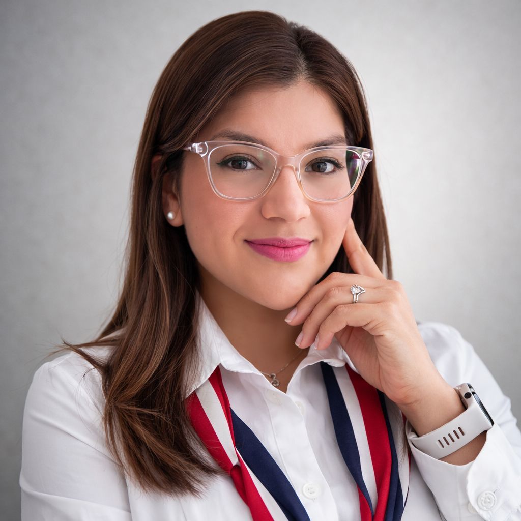 Woman with glasses, white shirt, and a colorful scarf, touching her face with a thoughtful expression.