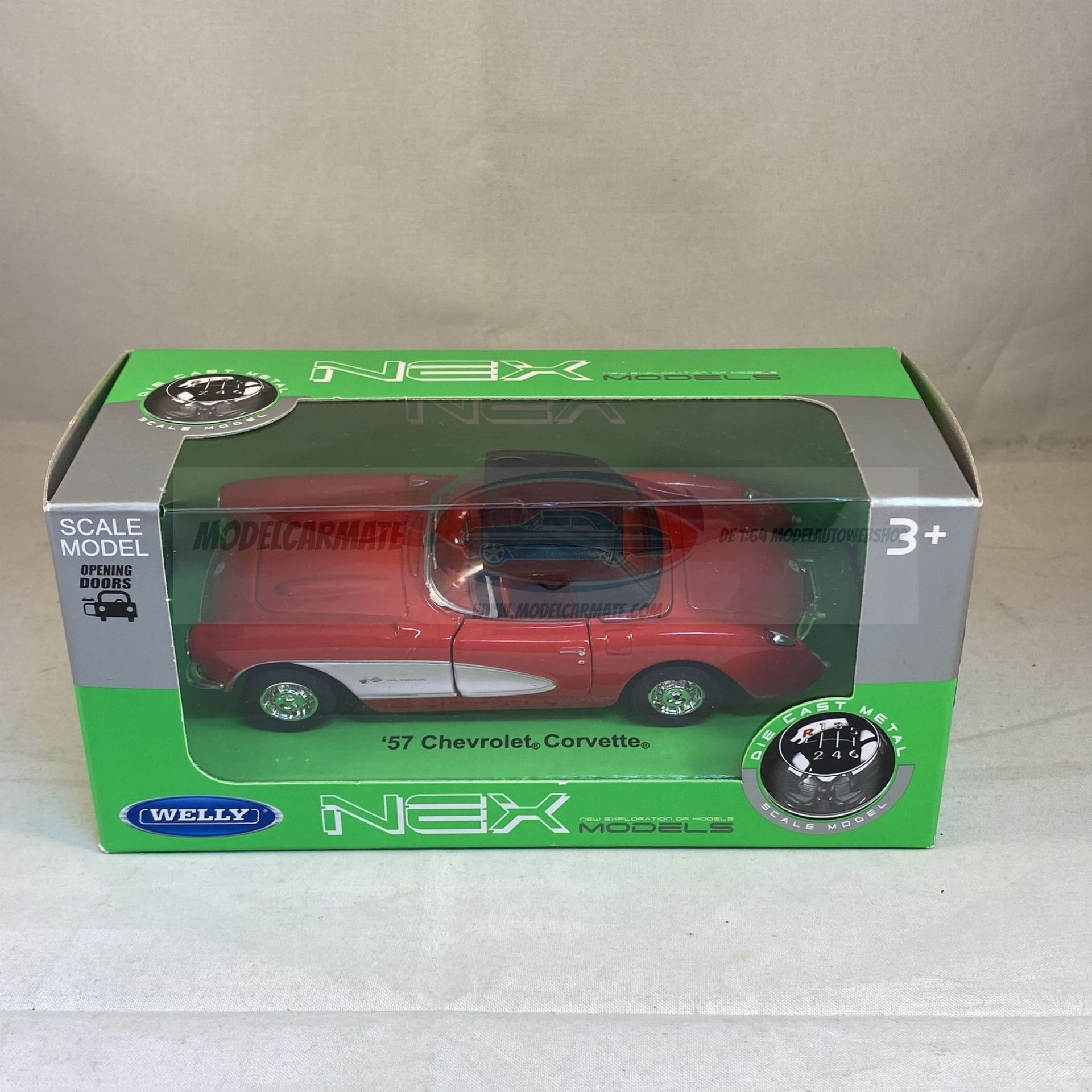 Rood speelgoedautootje in een groene en transparante plastic doos met het opschrift '57 Chevy, Corvette'.