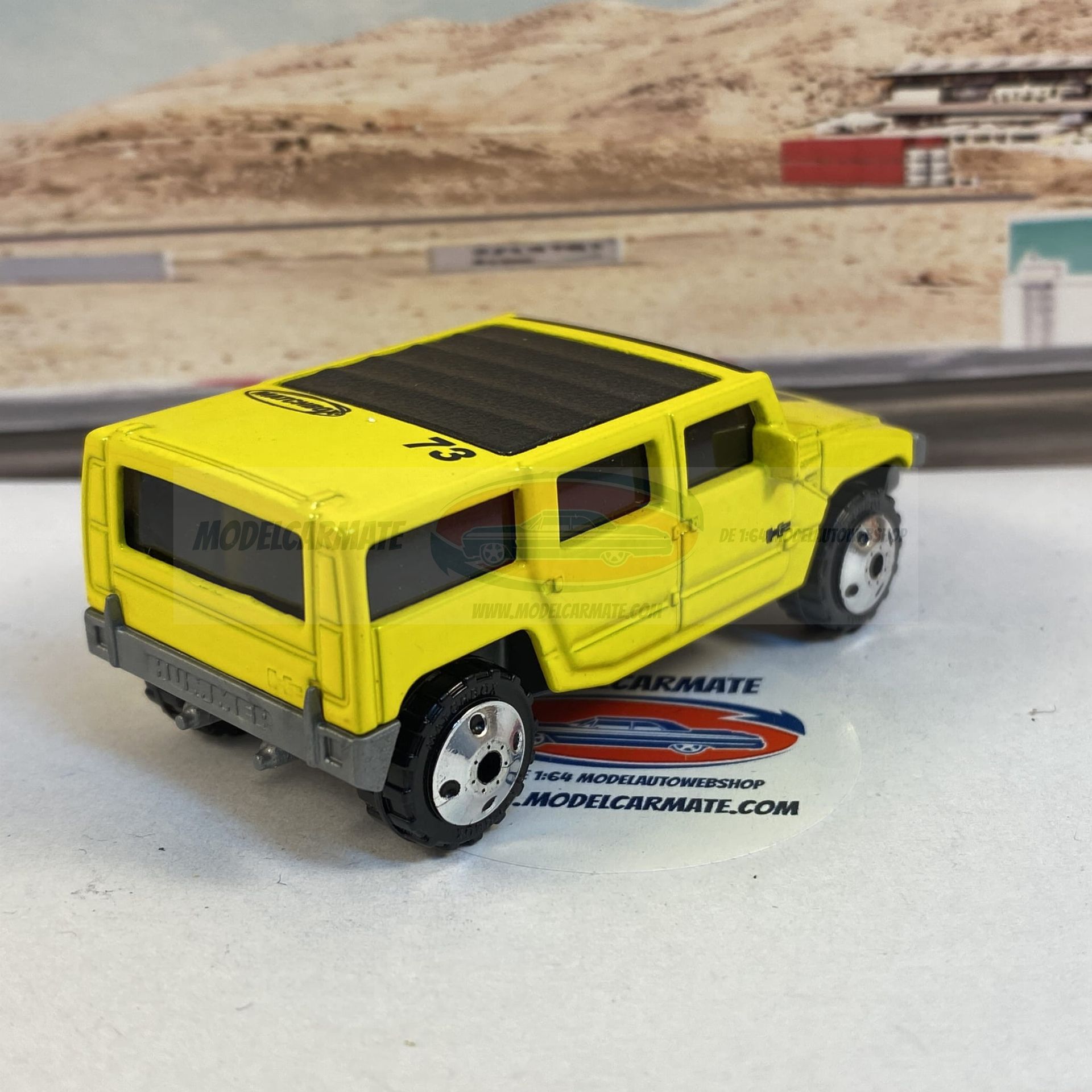 Gele speelgoed-Hummer SUV met zwart dak op een racebaanachtergrond.
